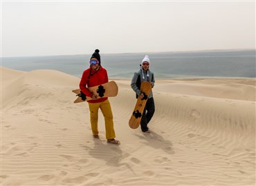 Snowboard Sporcuları, Karlı Yamaçlarda Snowboarding Yerine Katar'ın Kum Tepelerinde Kum Sörfü Yapmaya Hazırlanıyor 